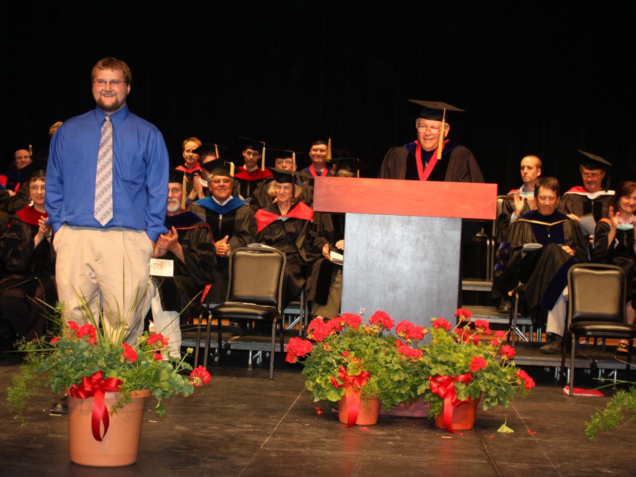 Bill Ackerman presents an award to an honors student at an academic celebration