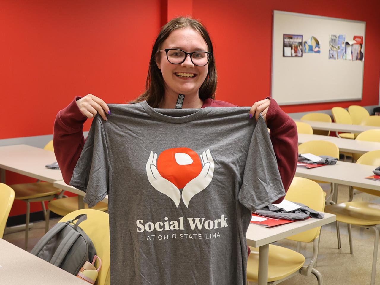 A social work student holds up her new shirt at Ohio State Lima