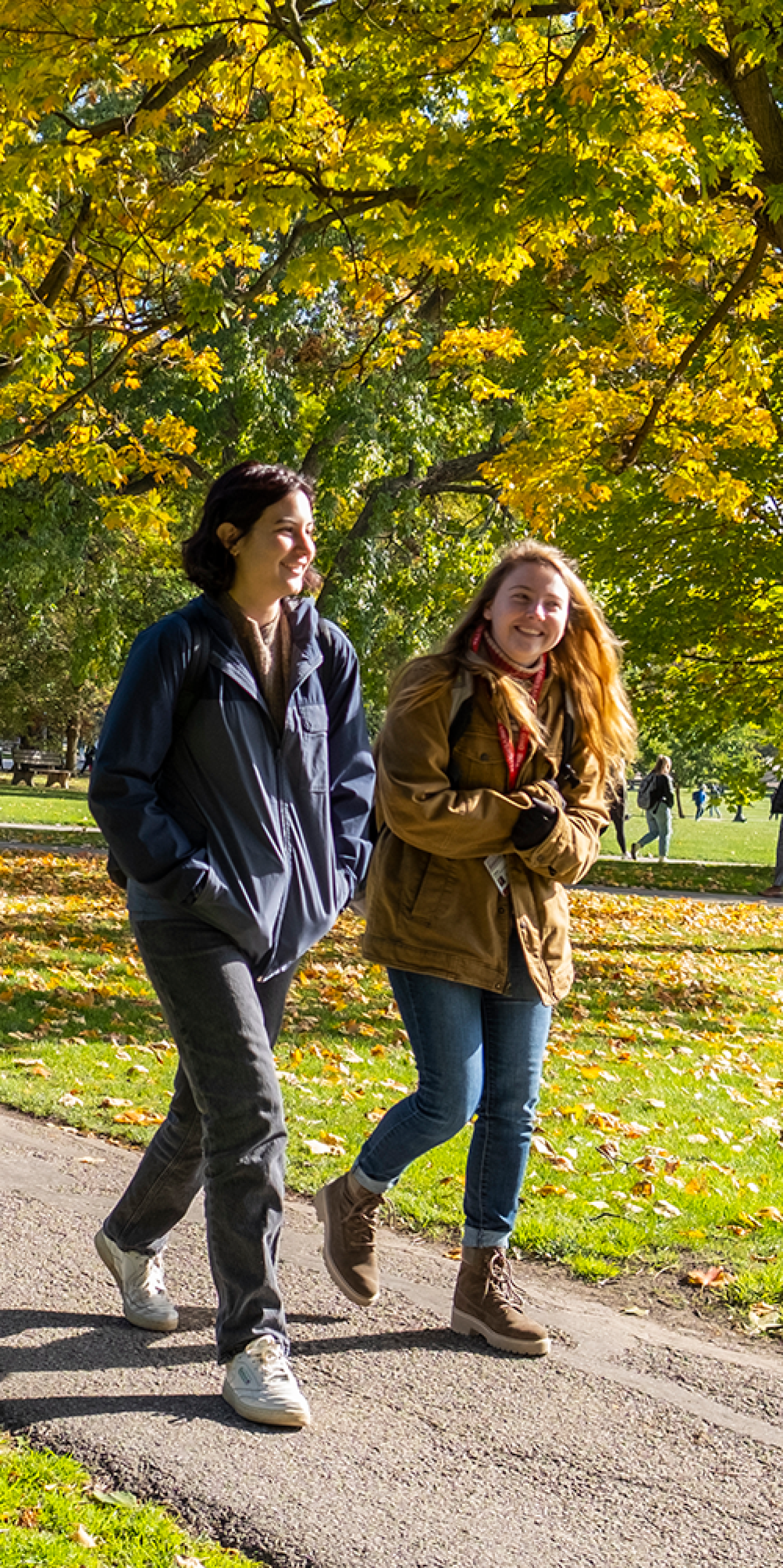 two female students walking outside on a campus walkway