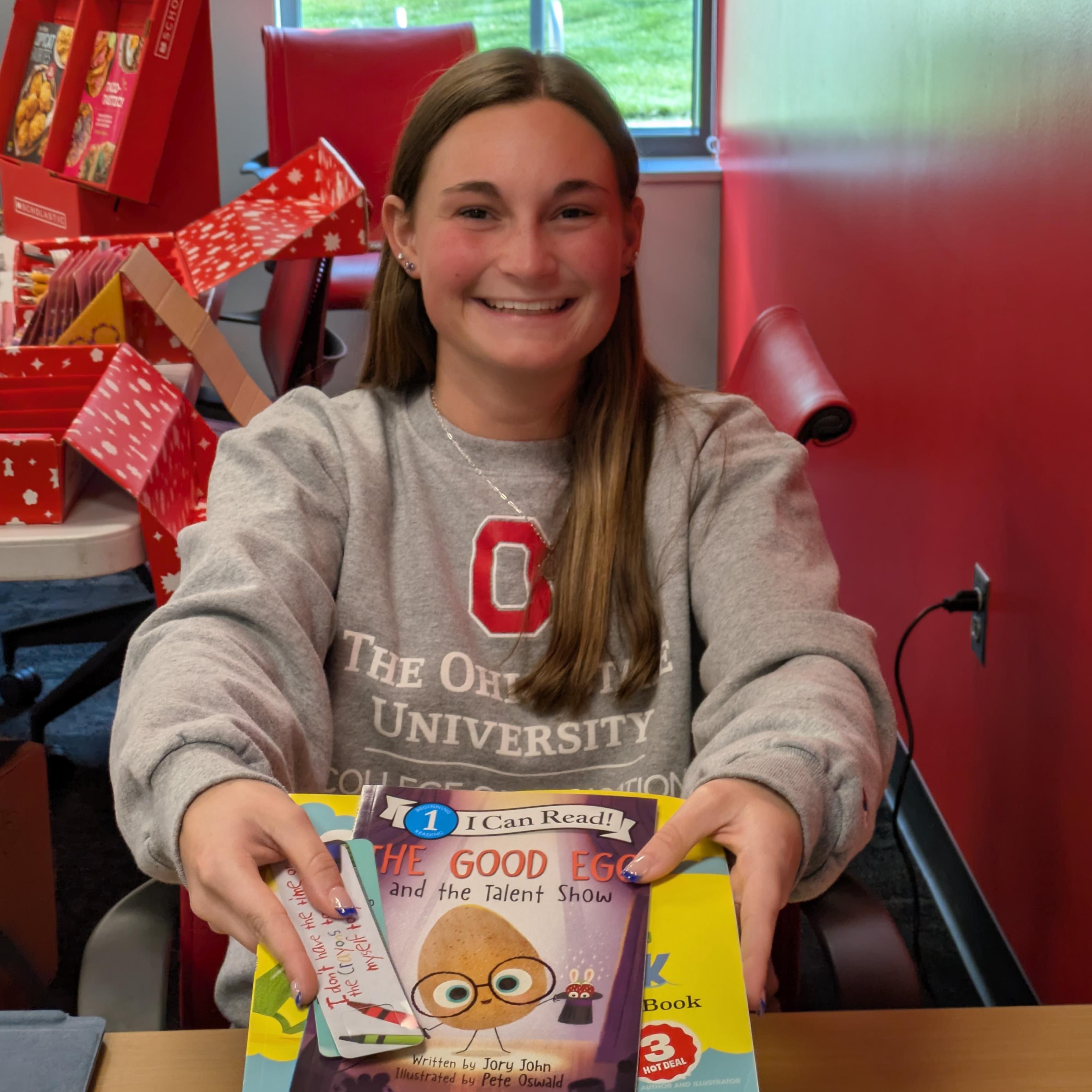 An Ohio State Lima student rings up a book sale at the Scholastic Book Fair. 