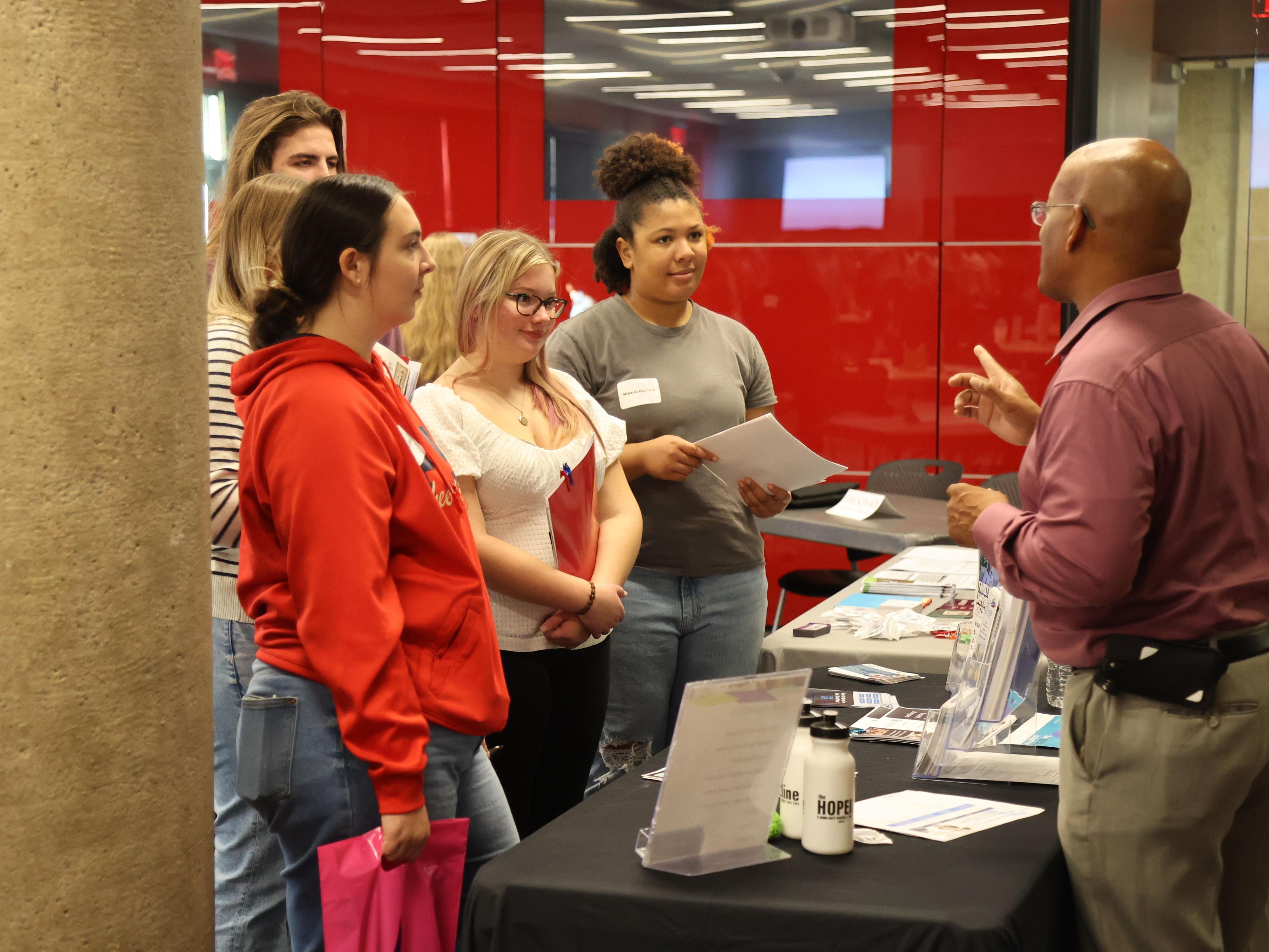 Three high school students talk to a social worker at Ohio State Lima