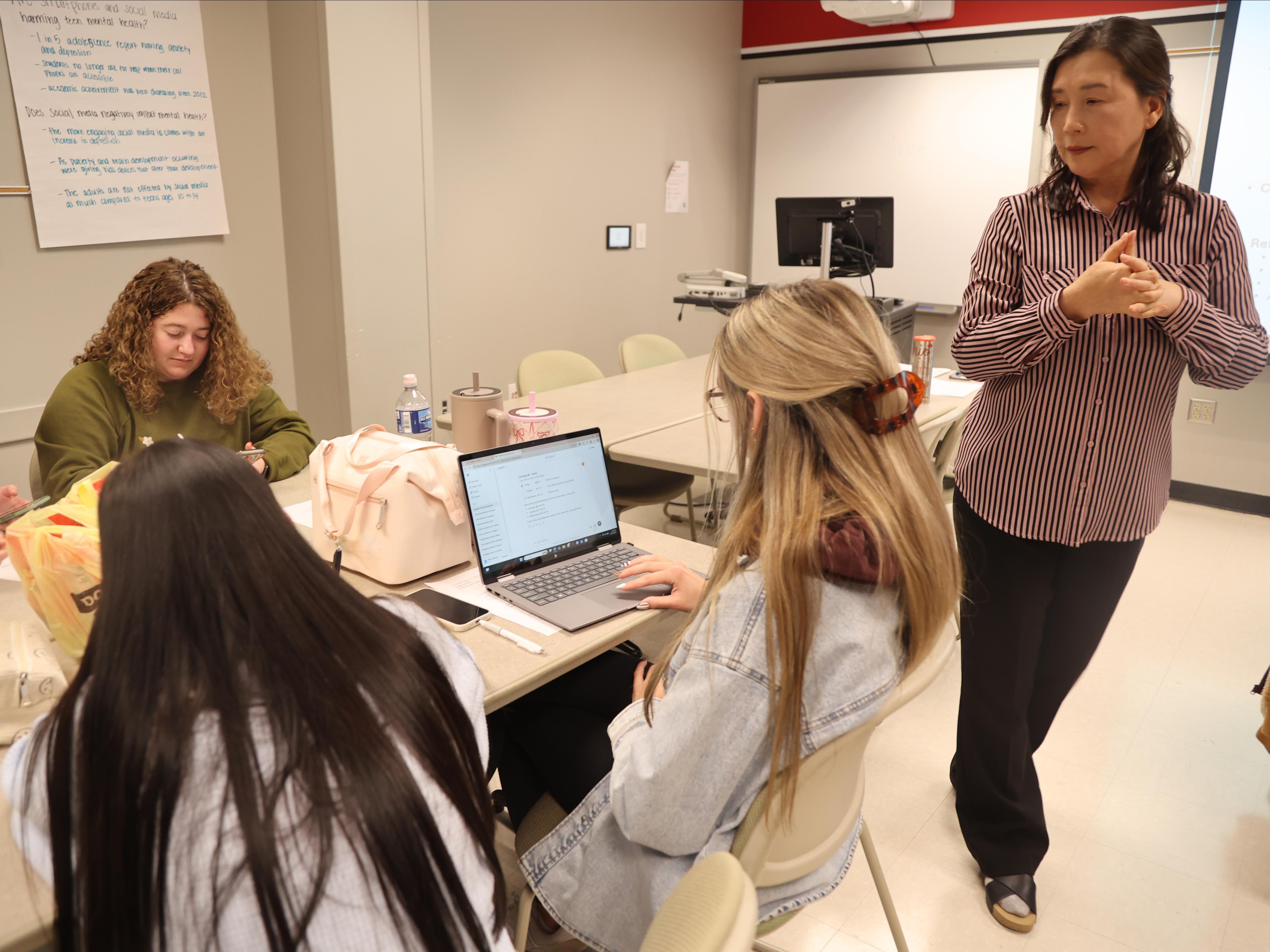  A professor observes a student working on an AI assignment on a laptop