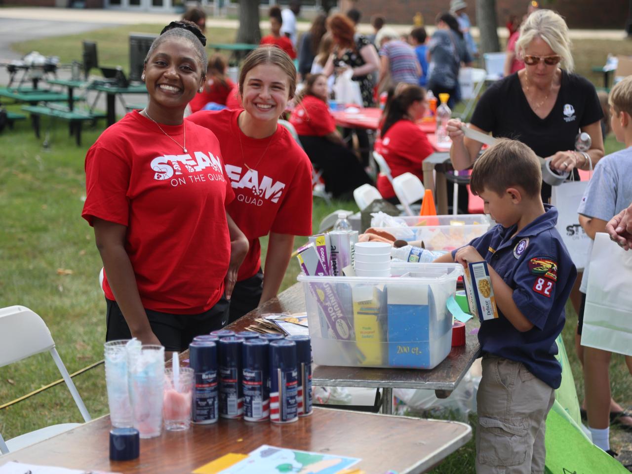 Students gather around a table at STEAM on the Quad