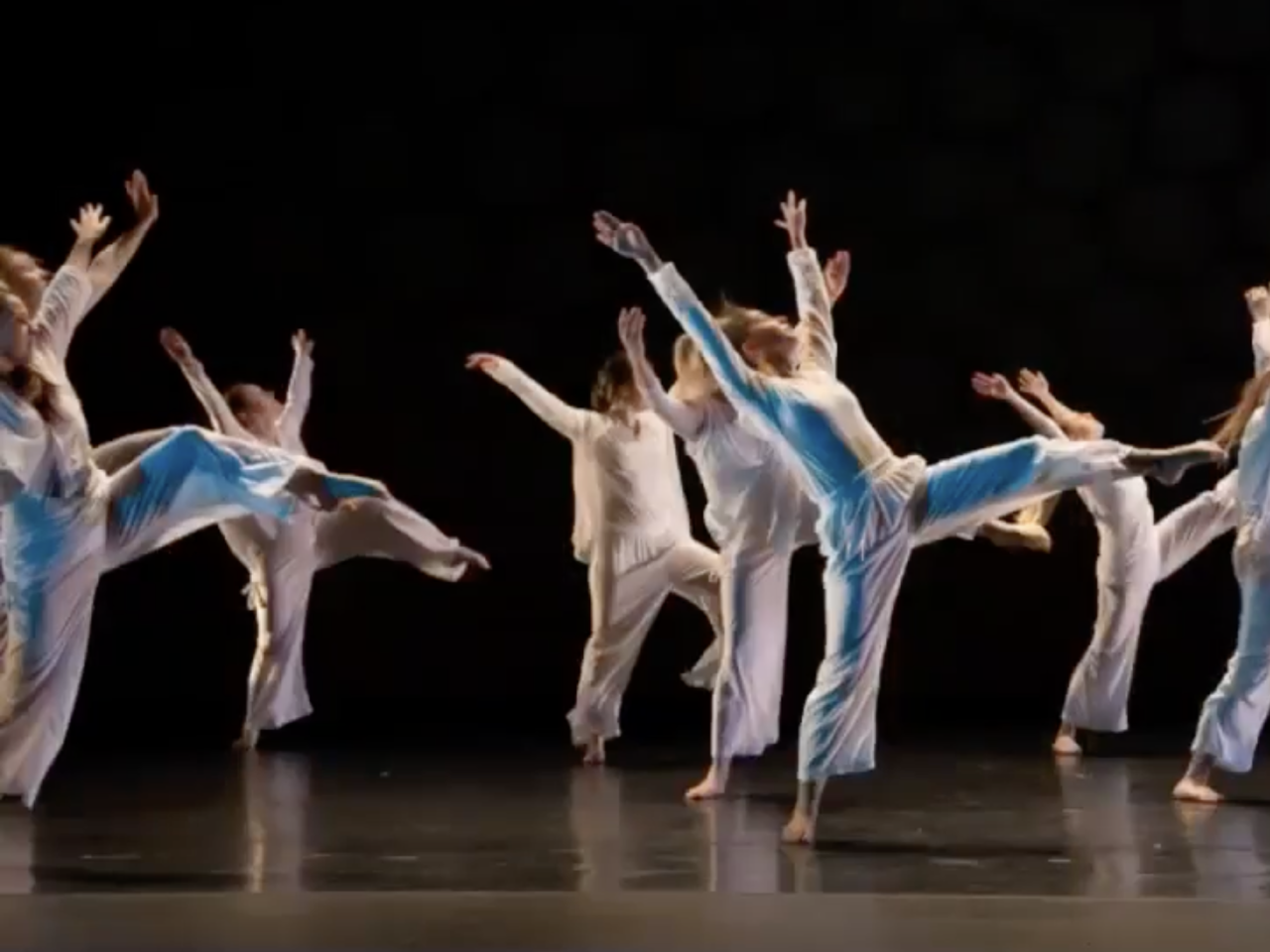Dancers in white on a stage