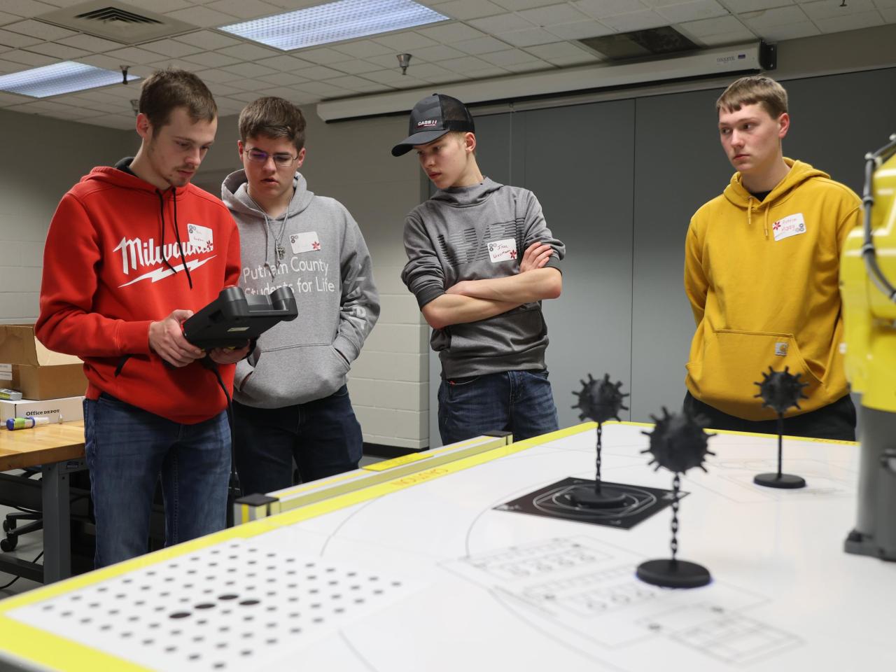 Four students navigate a robotics challenge