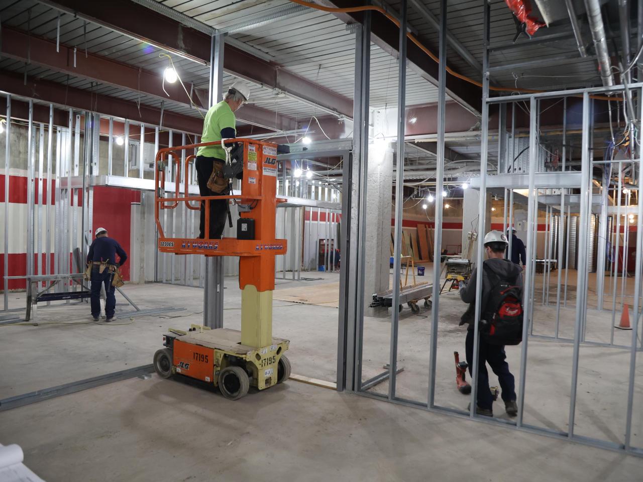 Construction workers using equipment to put up metal framing for walls in Galvin basement 2023-01-18-2