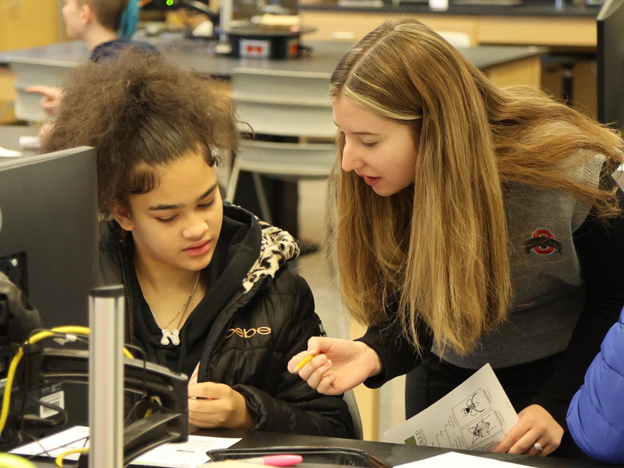 Two people look over a paper in a science lab