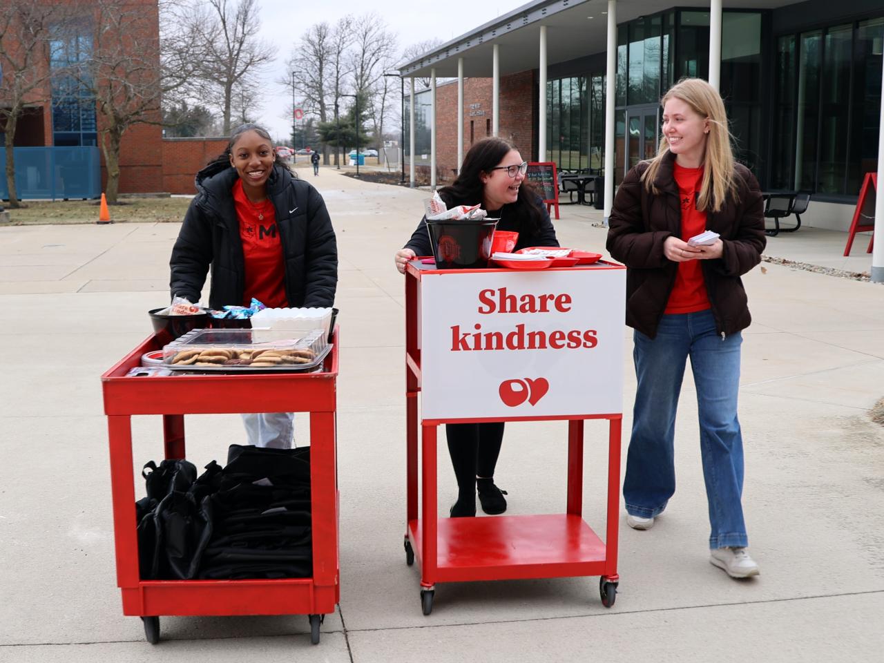 Students walk toward Galvin Hall with Share Kindness cookie carts