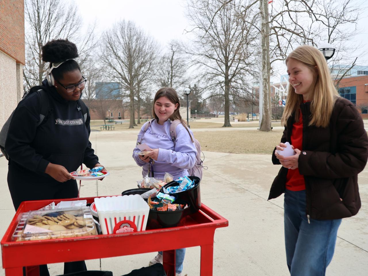 Students stop at the Share Kindness cart in front of Galvin Hall