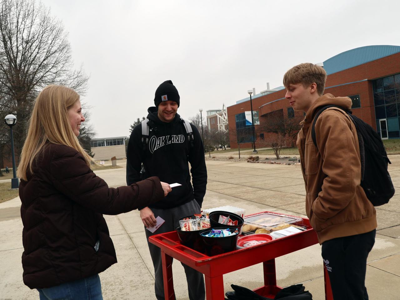 Students stop at the Share Kindness cart in front of Galvin Hall