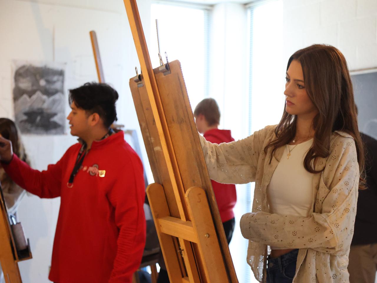 Student draws at an easel at Ohio State Lima