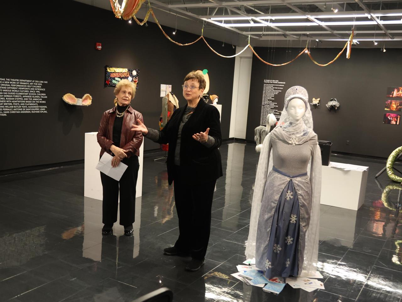 Speakers at the celebration of Theatre for Young Audiences stand in a display at the Farmer Family Gallery