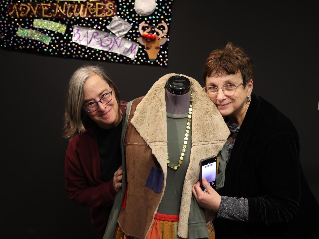 Theatre professors gather around a troll costume from Theatre for Young Audiences
