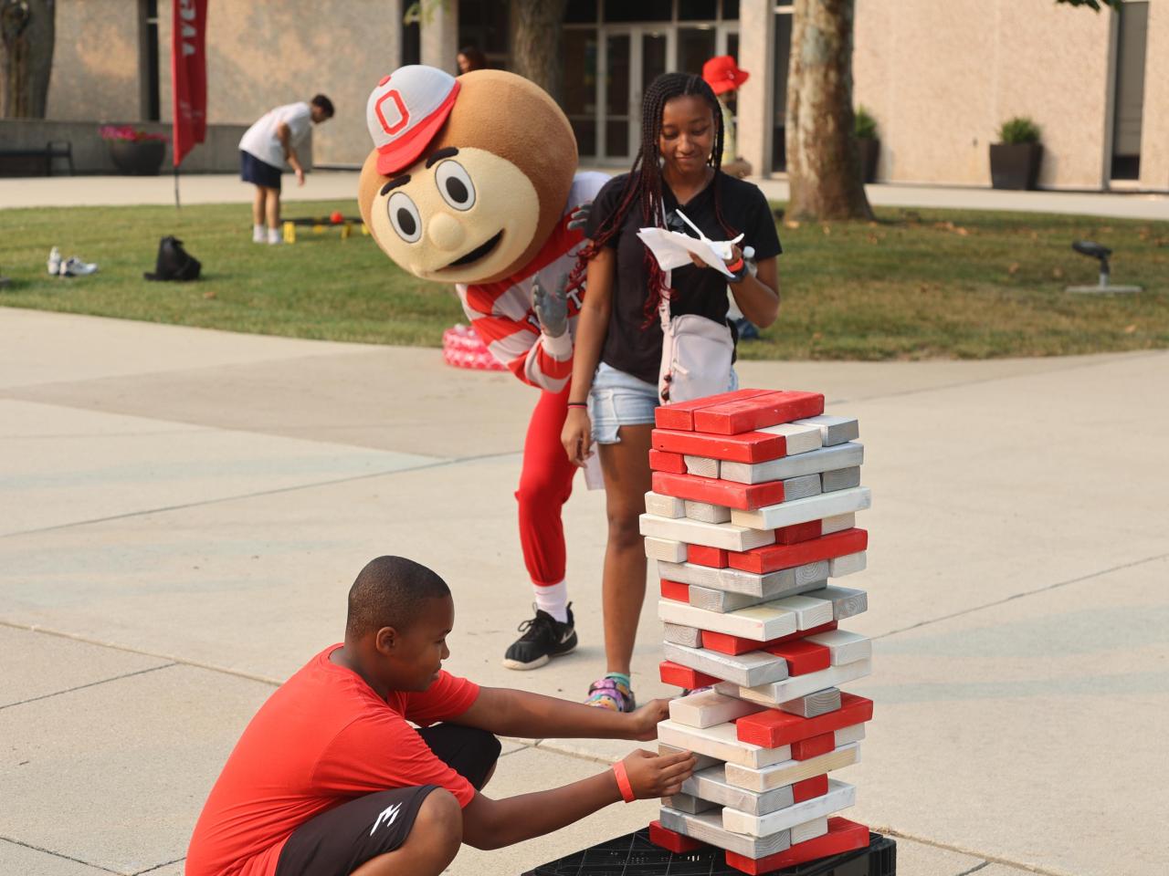 Brutus Buckeye plays giant jenga in front of Galvin Hall