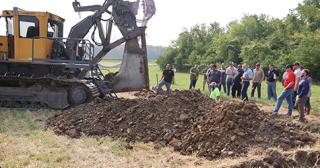 Field day participants watch a drainage plow 