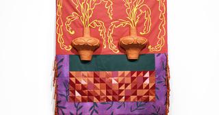 terracotta pots in front of a tapestry