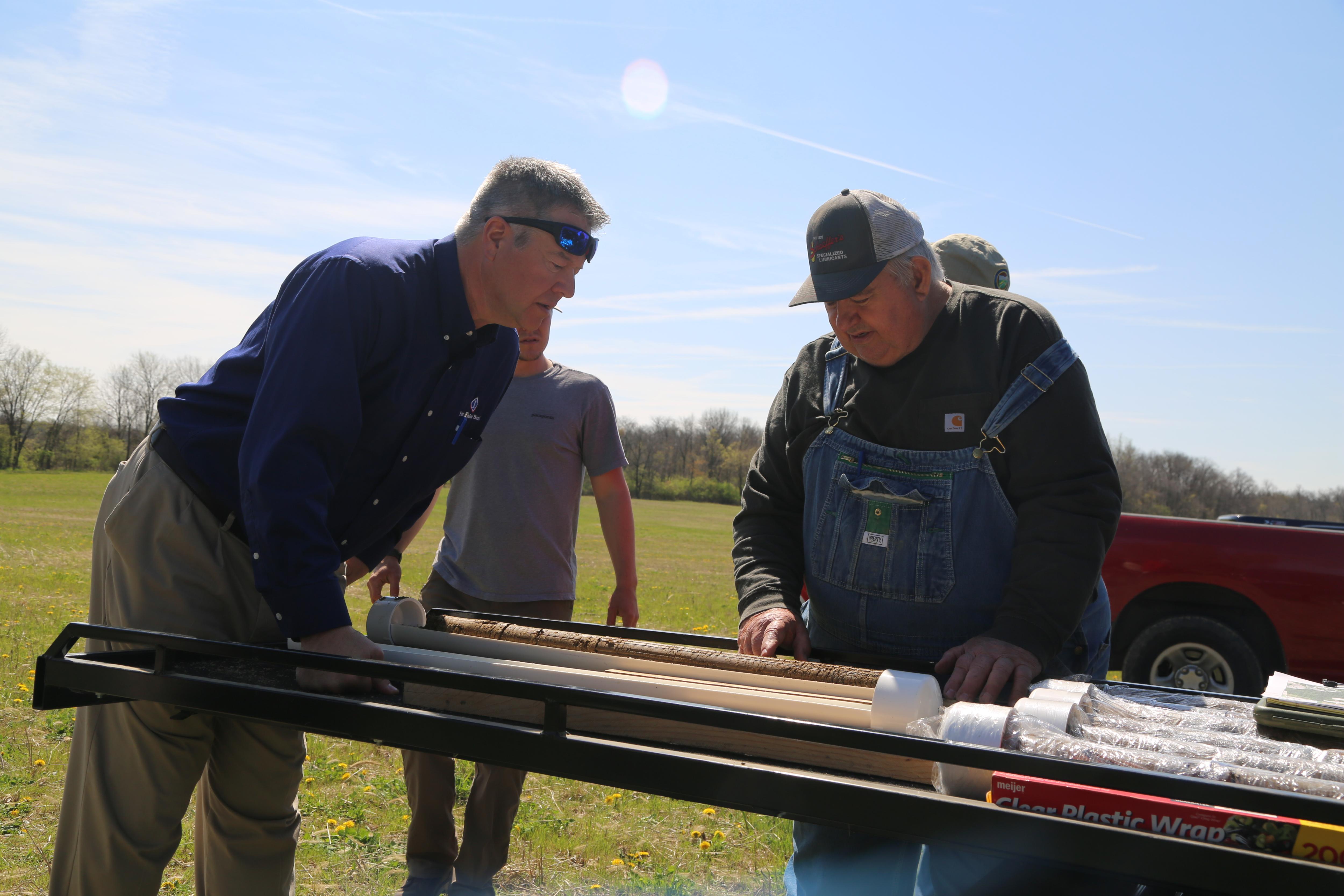 Farmers examine soil borings