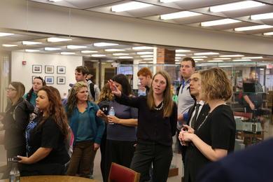 research student showing her work in the library