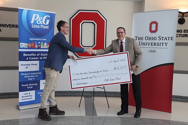 Representative of Proctor and Gamble handing a check to Ohio State Lima