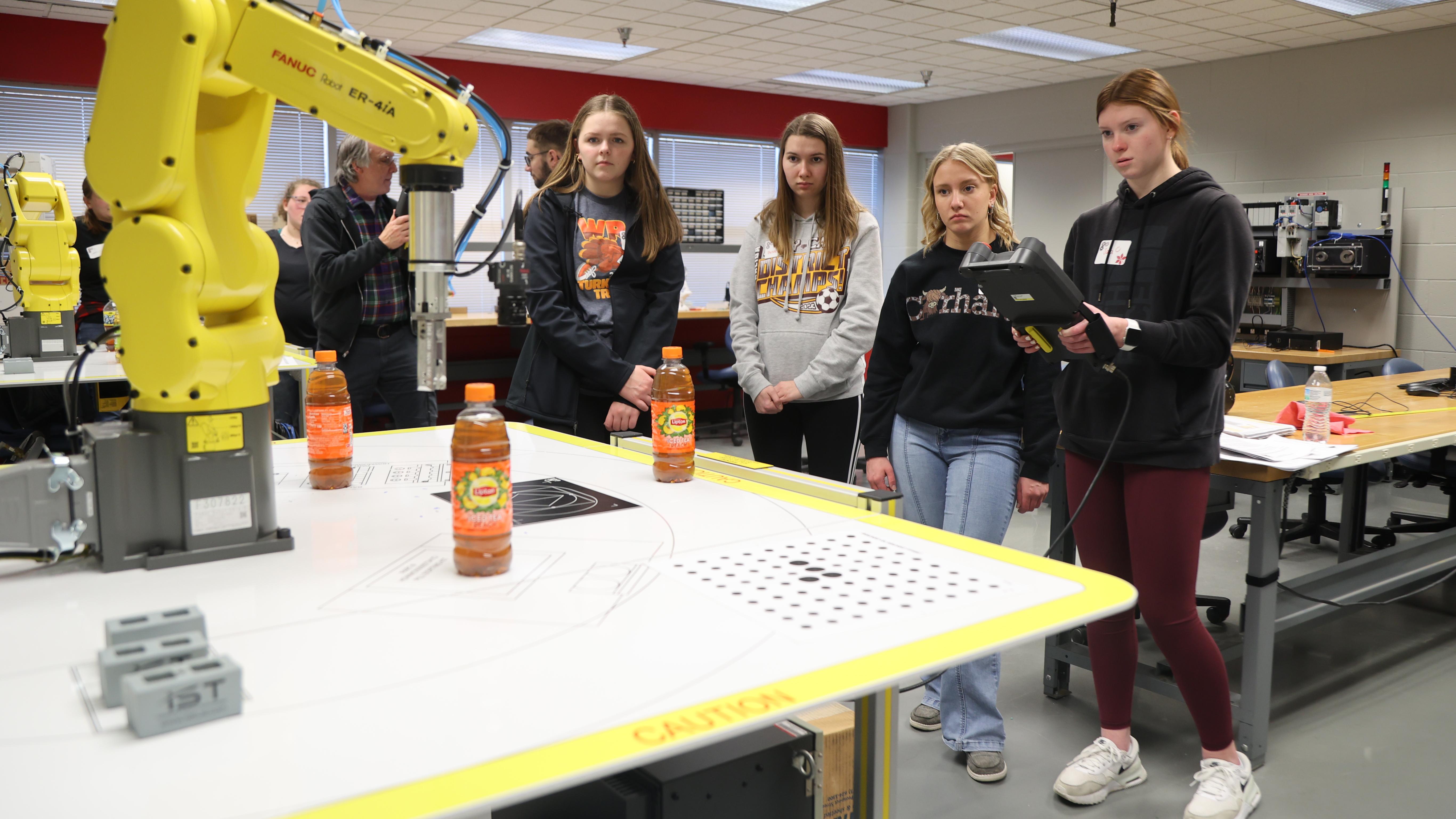 Four Putnam County 4-H members use a robot to move items