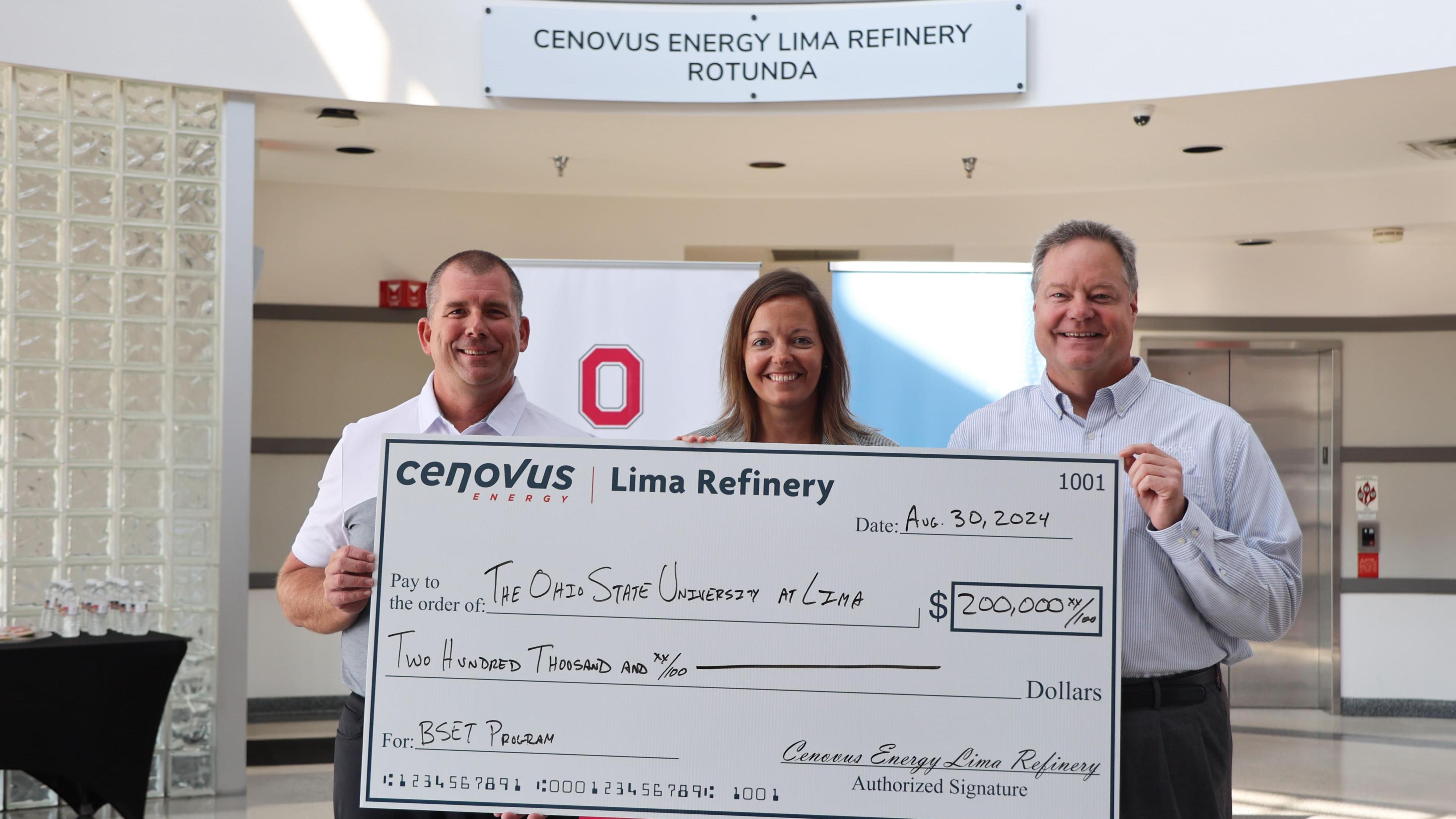 Three people hold a check in Ohio State Lima's Cenovus Energy Lima Refinery Rotunda