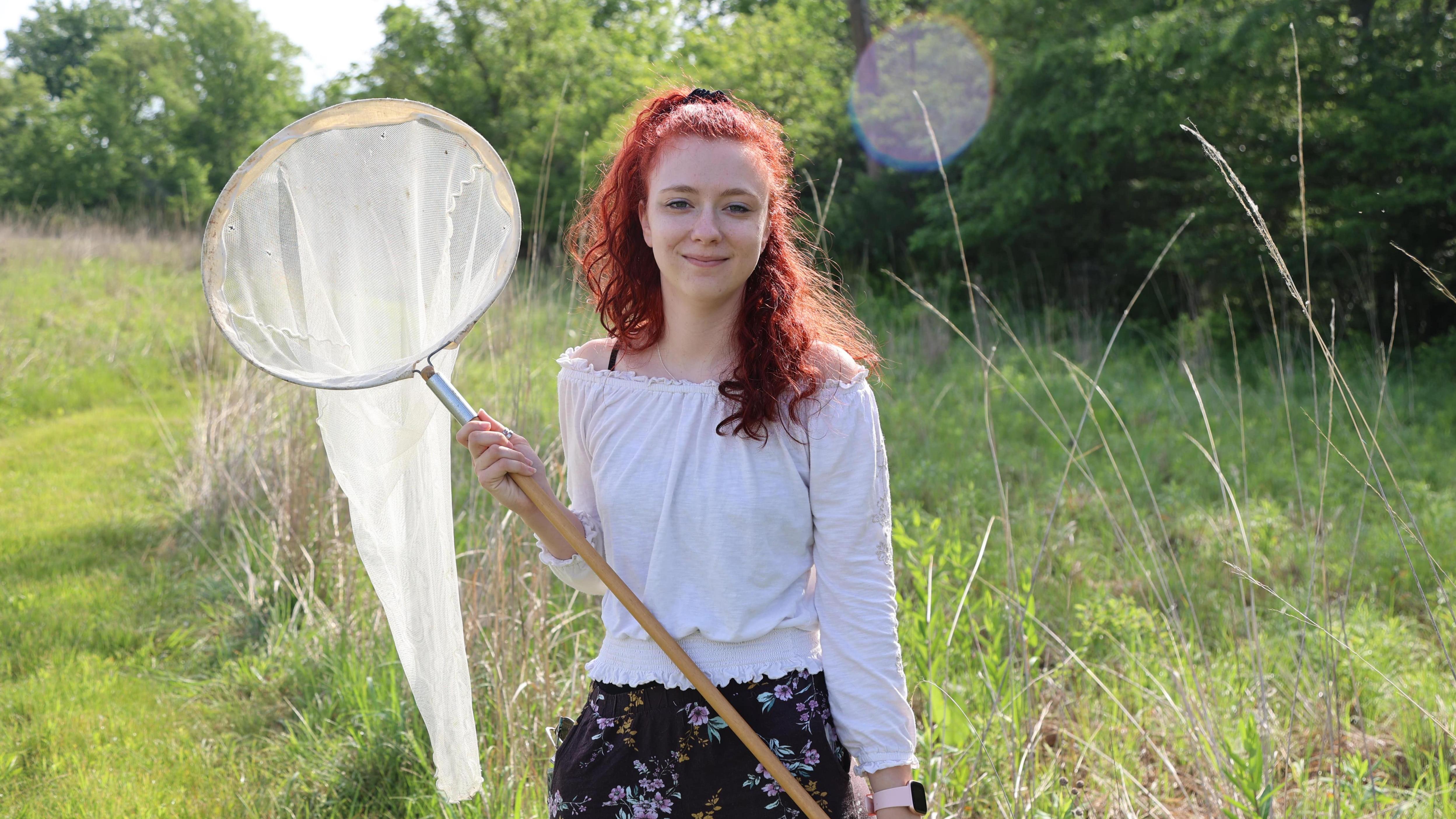 A student with an insect net at Ohio State Lima's prairie