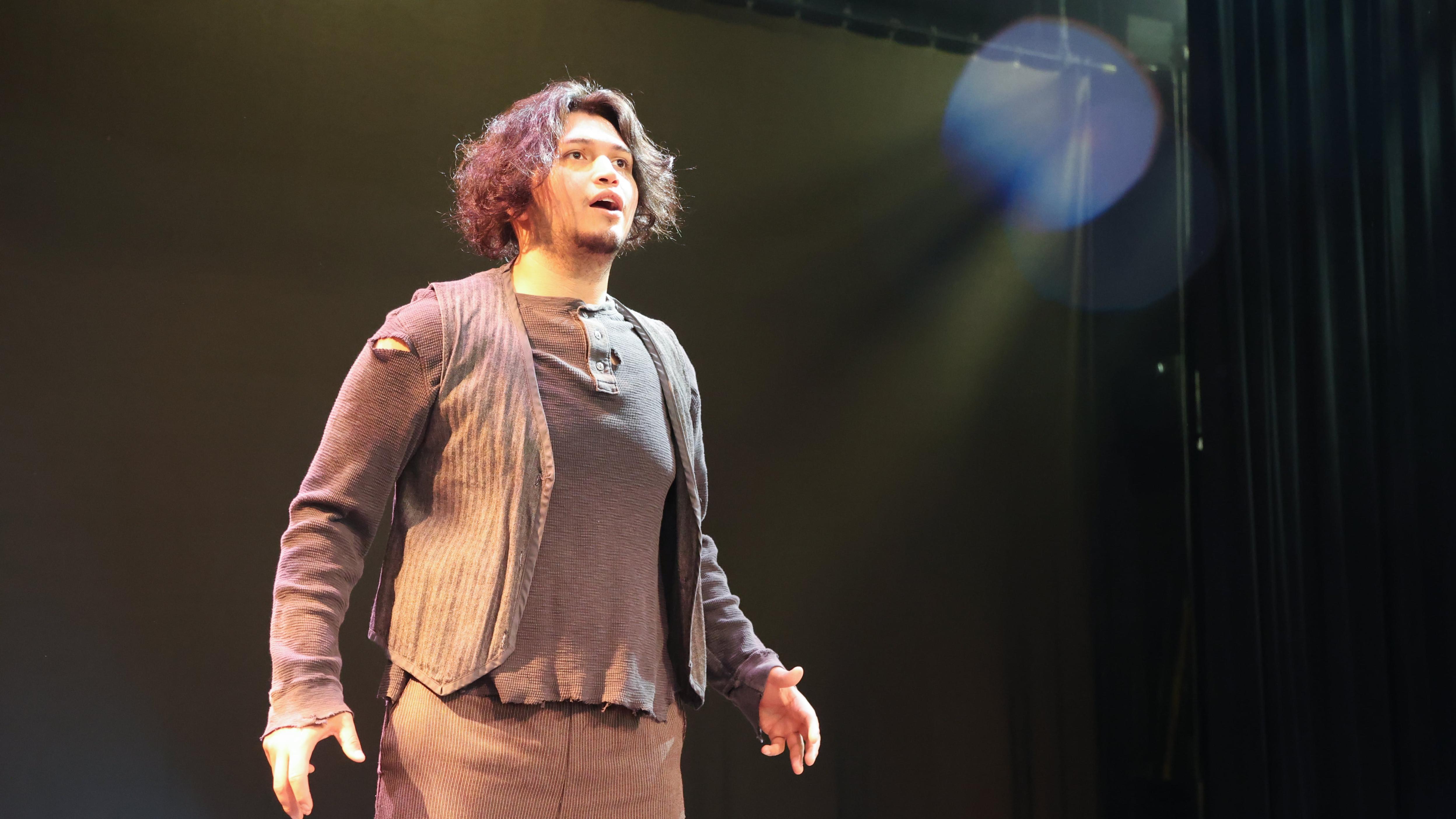 Jose Jones stands on the stage in the Martha W. Farmer Theatre for the Performing Arts