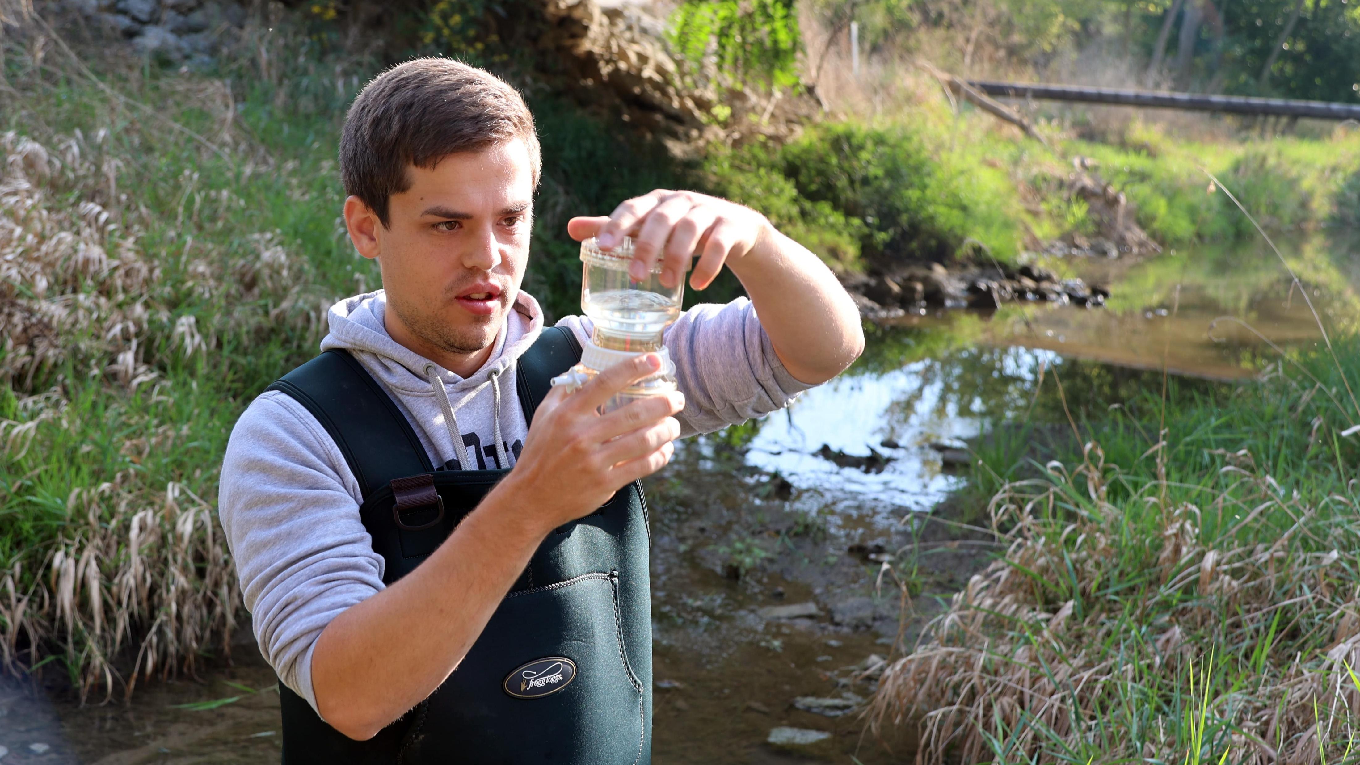 Undergrad researcher Carter Welch tests water from Lost Creek