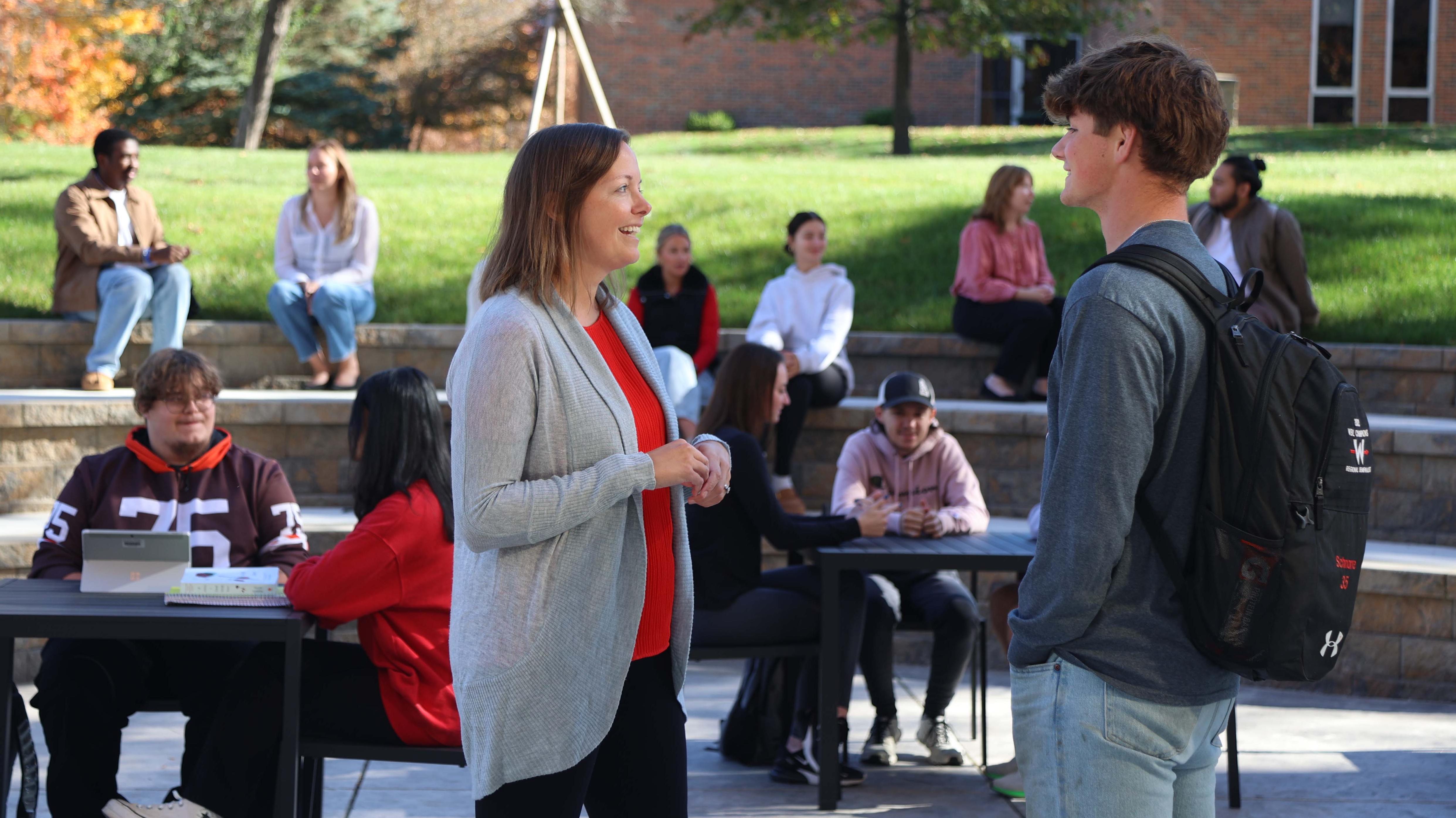 Dean Young talks to a student on the Galvin patio