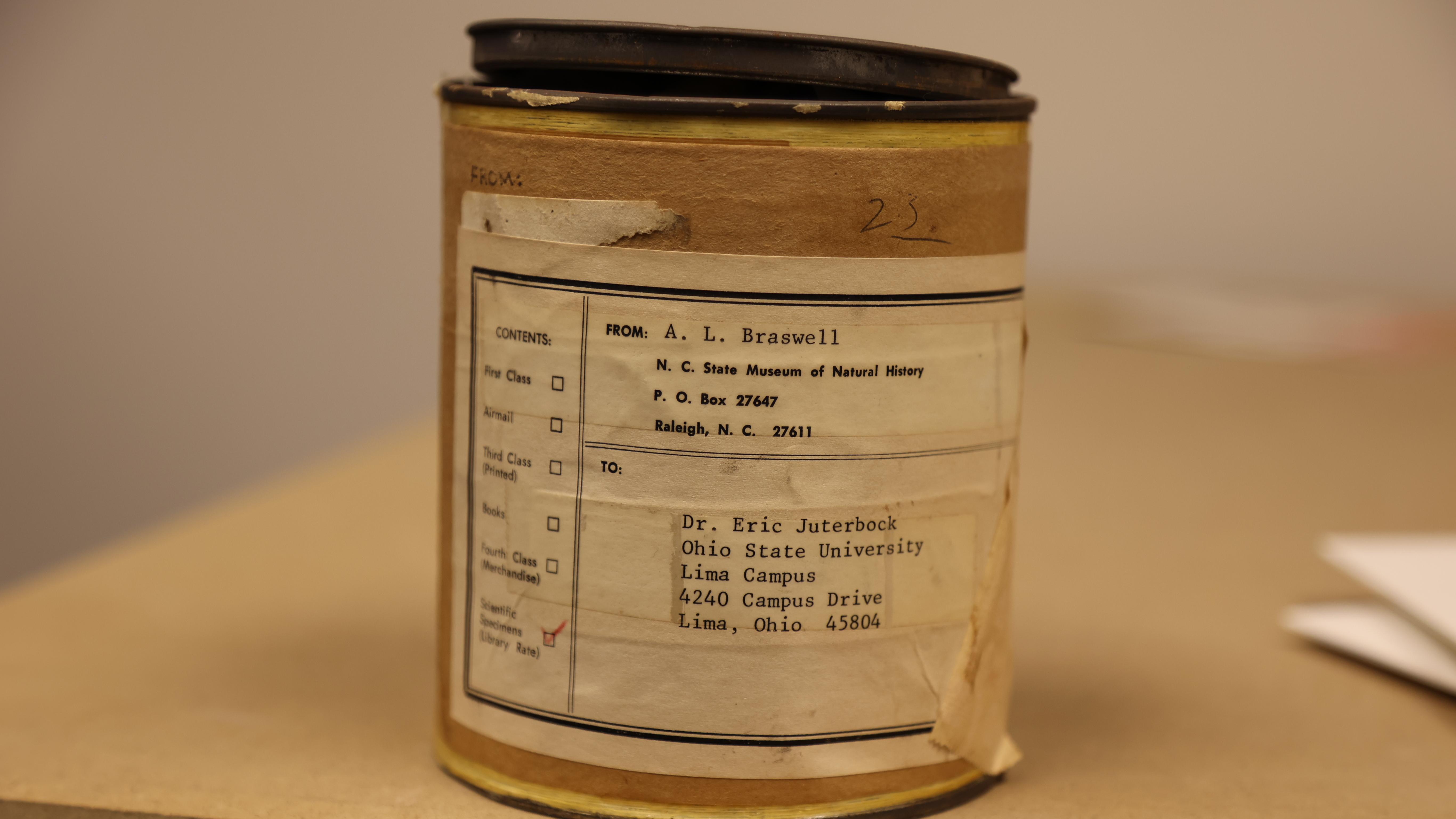 A battered cardboard tube mailer