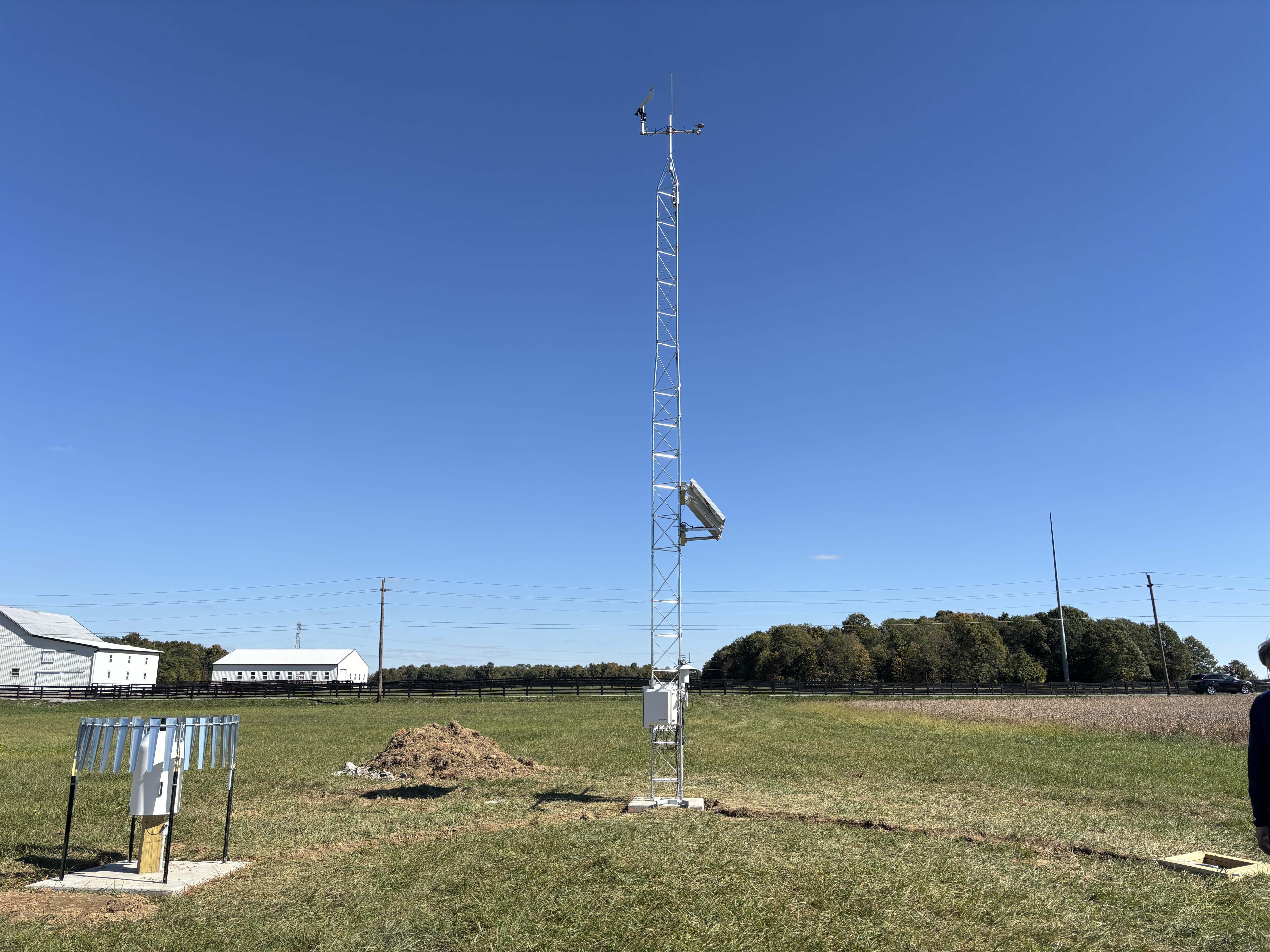 A metal tower in a green field