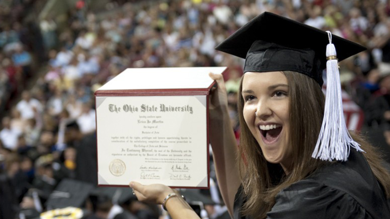 Photo of a girl showing her diploma during commencement ceremony