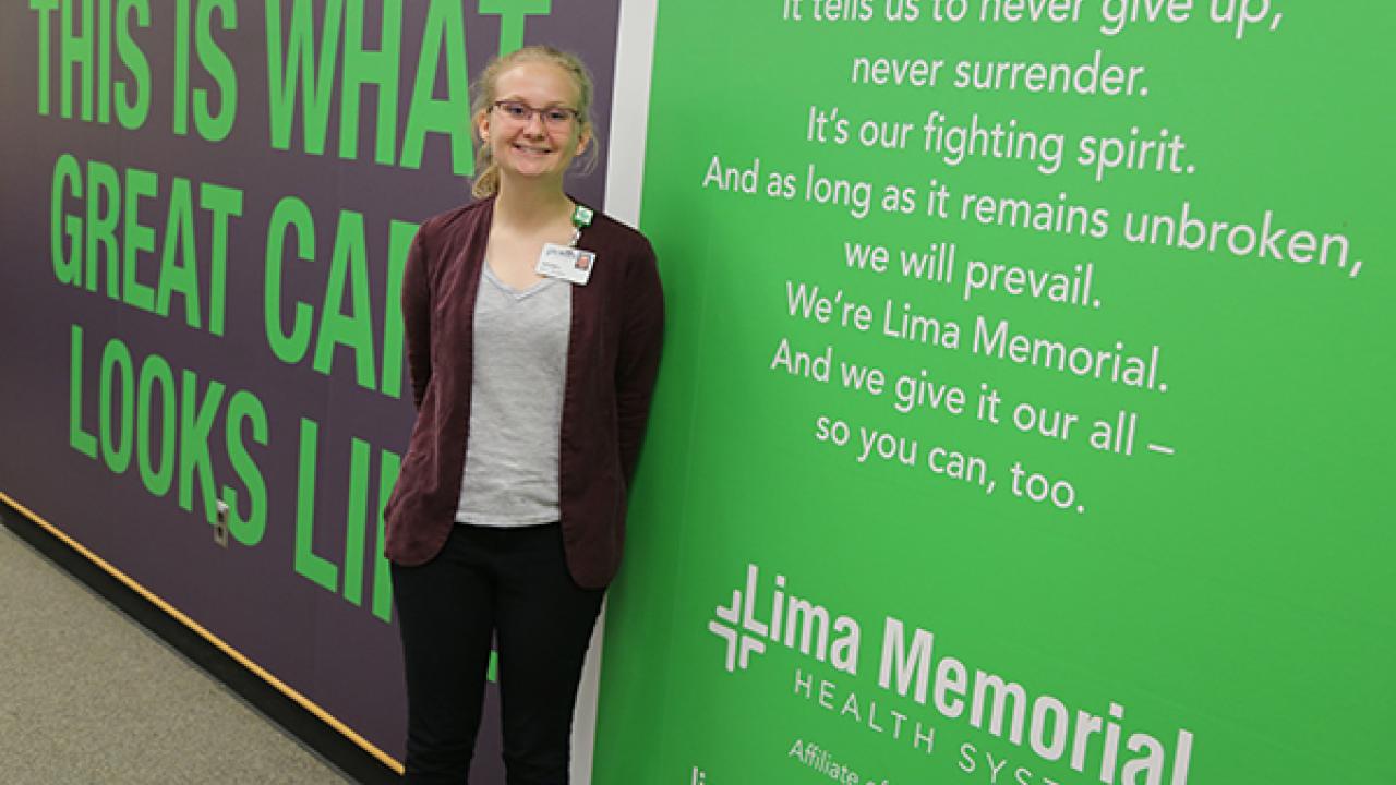 Girl standing in front of a Lima Memorial Health System sign
