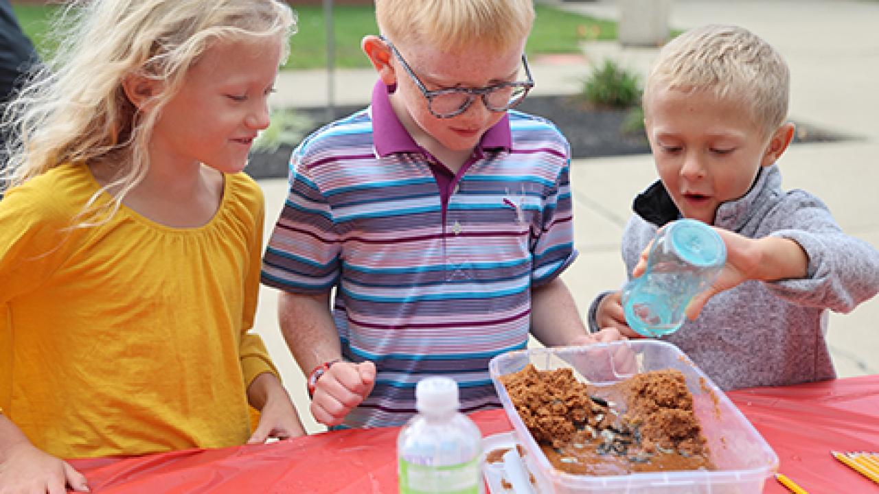 Three kids doing an erosion experiment